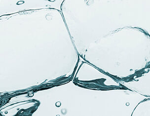 Ghiaccio trasparente e bollicine in acqua, creando un effetto fresco e rinfrescante.