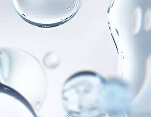 Gocce d&apo;acqua trasparenti fluttuano su uno sfondo sfocato, creando un effetto luminoso e cristallino.