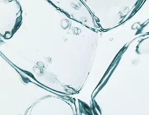 Bollicine e cubetti di ghiaccio immersi in acqua trasparente, creando un effetto visivo fresco e dinamico.