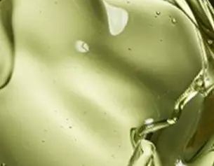 Liquido d&apo;olio verde chiaro che si muove e crea riflessi, evidenziando la sua consistenza viscosa.