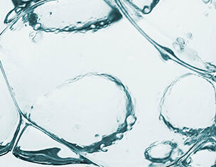 Bollicine d'acqua trasparente su sfondo chiaro, creando un effetto di freschezza e leggerezza.