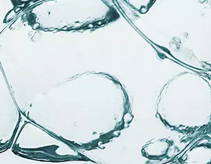 Bollicine d'acqua trasparente su sfondo chiaro, creando un effetto di freschezza e leggerezza.