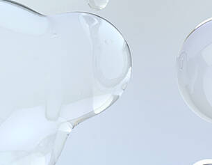 Gocce di gel trasparente su uno sfondo chiaro, creando un effetto di eleganza e leggerezza.