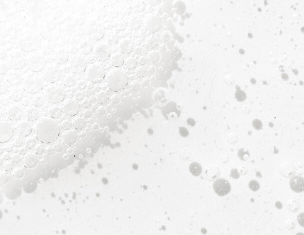 Close-up of white bubbles on a light surface, creating a textured, frothy appearance.