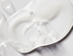 A clear, viscous gel spread across a smooth surface, reflecting light and showcasing its translucent texture.