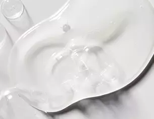 A clear, viscous gel spread across a smooth surface, reflecting light and showcasing its translucent texture.