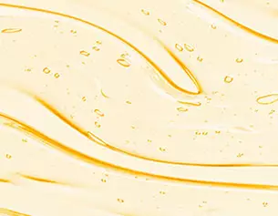 Superficie di gel dorato con bollicine, che crea un effetto fluido e luminoso.