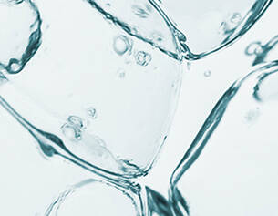 Close-up of clear ice cubes submerged in water, creating bubbles and a refreshing, cool atmosphere.
