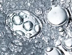 Close-up of bubbles in liquid, showcasing varying sizes and light reflections.