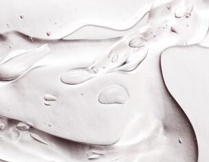 Dettaglio di una superficie lucida con gocce d’acqua e riflessi, creando un effetto elegante e dinamico.