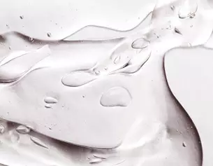 Dettaglio di una superficie lucida con gocce d’acqua e riflessi, creando un effetto elegante e dinamico.