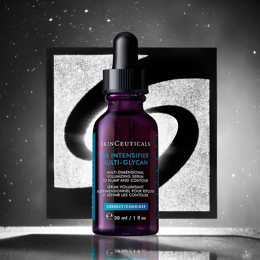 Una bottiglia di HA Intensifier Multi-Glycan davanti a uno sfondo nero e argento con il logo Skinceuticals.​