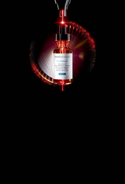 Un flacone di siero SkinCeuticals C E Ferulic, esposto su uno sfondo scuro con un effetto di luce rossa e un motivo bokeh circolare e luminoso
