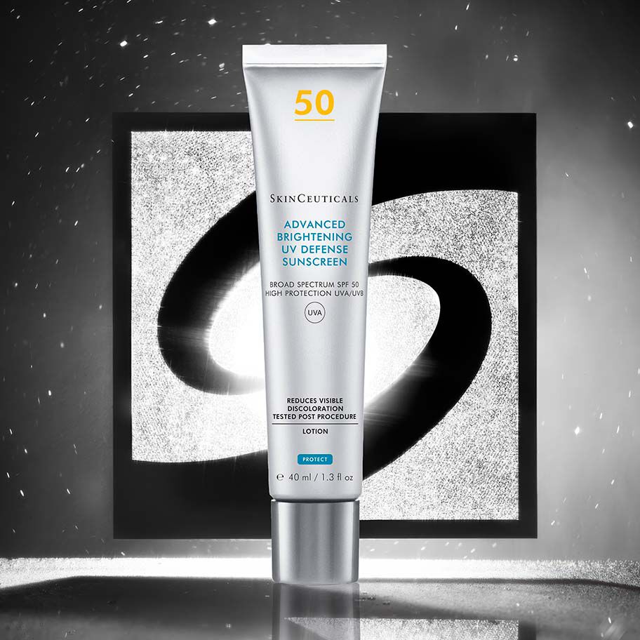 Una bottiglia di protezione solare Advanced Brightening UV Defense davanti a uno sfondo nero e argento con il logo Skinceuticals.