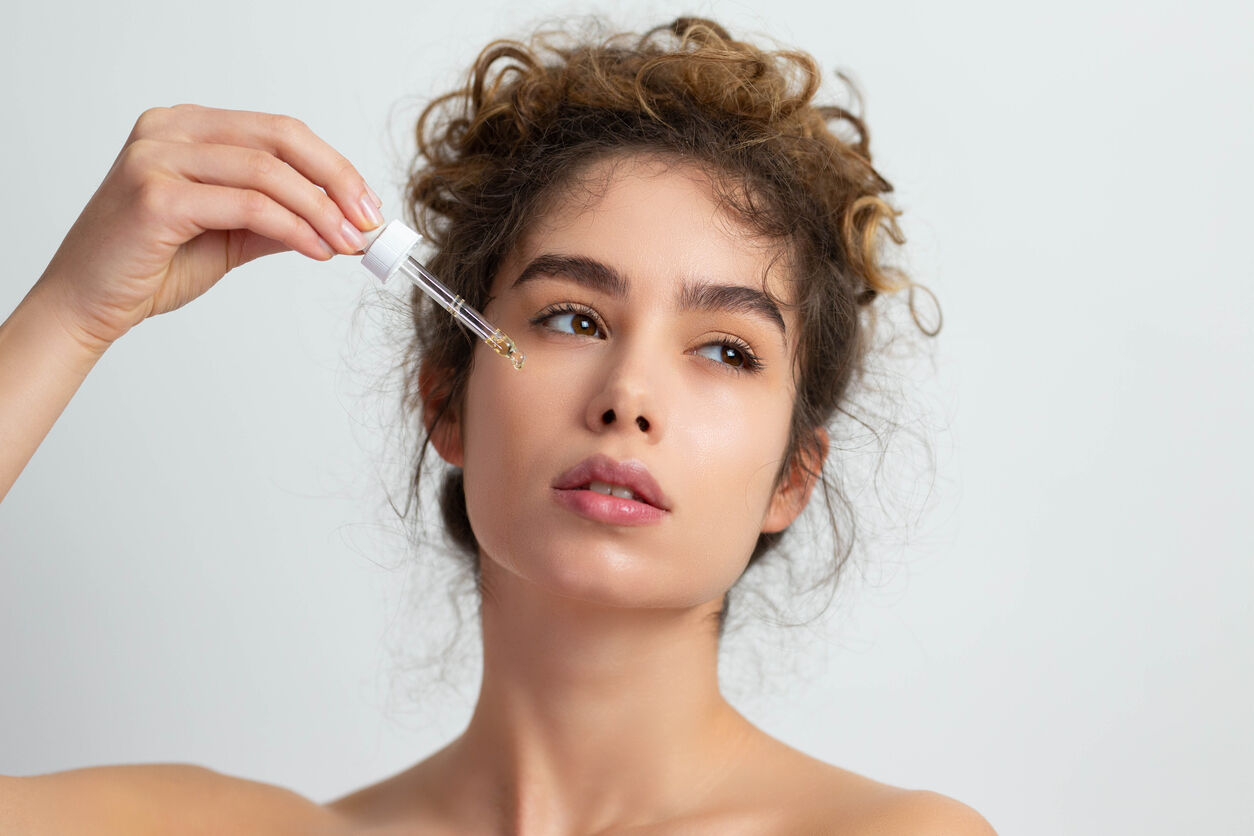 Ragazza che mette il siero sul viso